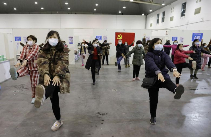 Các bệnh nhân đeo khẩu trang tập thể dục trong một bệnh viện dã chiến ở Vũ Hán.