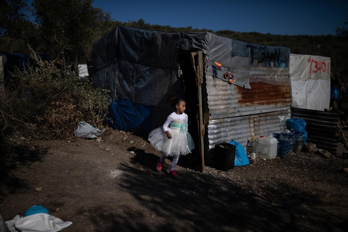Con gái của Talibshah, Parisa, chạy bên ngoài "ngôi nhà" tạm bợ của gia đình cô bé trên đảo Lesbos.