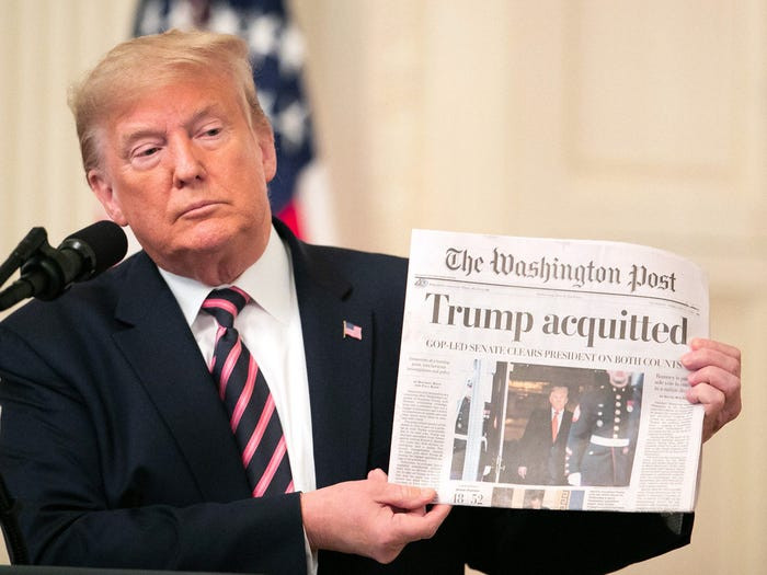 Tổng thống Mỹ Donald Trump cầm tờ báo của Washington Post đưa tin rằng ông được tha bổng trong phiên tòa luận tội hồi tháng 2/2020.