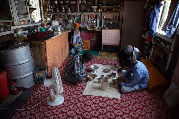 Ghulam Qadir Ota và các thành viên trong gia đình ngồi ăn trong nhà thuyền. "Chúng tôi không kiếm được đồng nào trong một năm nay. Tất cả những gì chúng tôi có là những chiếc thuyền này. Chúng tôi không có cách nào khác để kiếm tiền", Ota chia sẻ.