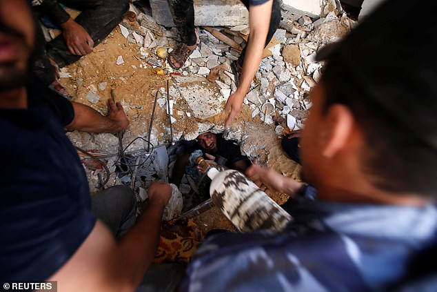 Lực lượng cứu hộ tìm kiếm người sống sót giữa đống đổ nát của một tòa nhà bị phá hủy ở Gaza.