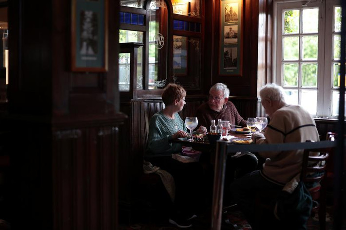 Mọi người vừa ăn vừa trò chuyện tại quán rượu The Fox on the Hill ở London.
