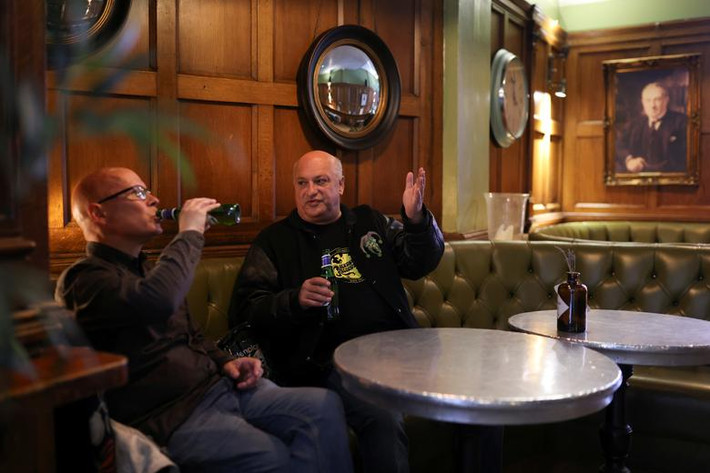 Hai người đàn ông uống bia, trò chuyện tại quán The Old Shades ở Whitehall, London.