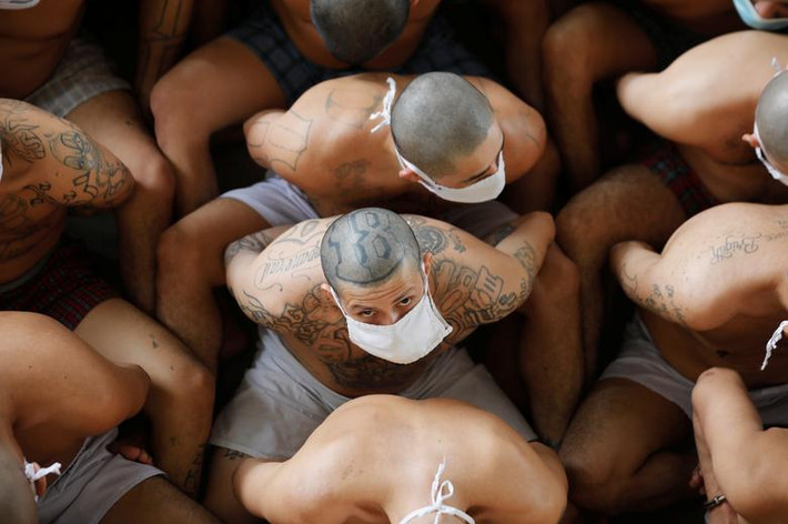 Họ ngồi sát nhau bên ngoài phòng giam ở nhà tù Izalco khi giới chức trách kiểm tra.