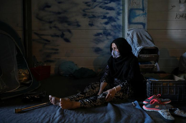 Người phụ nữ ngồi nghỉ trong nhà kho được sử dụng làm nơi ở tạm thời dành cho người tị nạn ngày 14/9.