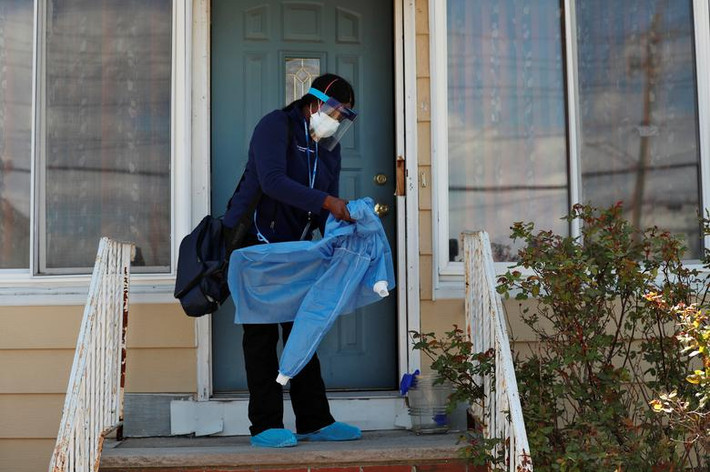 Flora Ajayi, nhân viên chăm sóc sức khỏe tại nhà, mặc đồ bảo hộ để bảo vệ bản thân và tránh lây nhiễm chéo khi tới thăm một khách hàng ở khu Queens hôm 22/4.