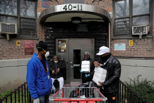 Các tình nguyện viên đi phân phát thực phẩm cho người dân tại khu nhà ở công cộng Queensbridge, Queens, ngày 21/4.