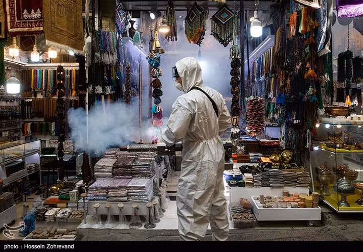Nhân viên phun thuốc khử trung tại một cửa hàng ở khu chợ Tajrish, thủ đô Tehran.