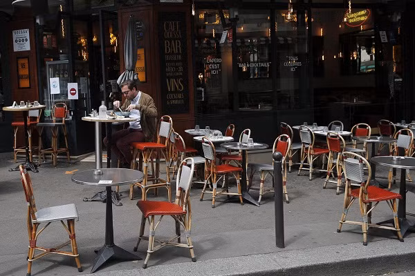 Người đàn ông ngồi ăn ngoài trời tại một nhà hàng ở thủ đô nước Pháp.