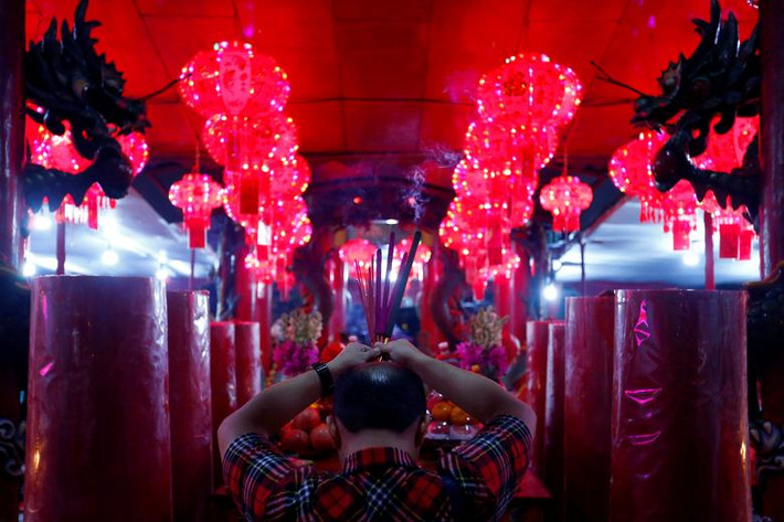 Một người đàn ông thắp hương tại ngôi đền ở thủ đô Jakarta, Indonesia, trong đêm Giao thừa. Ảnh: Reuters.