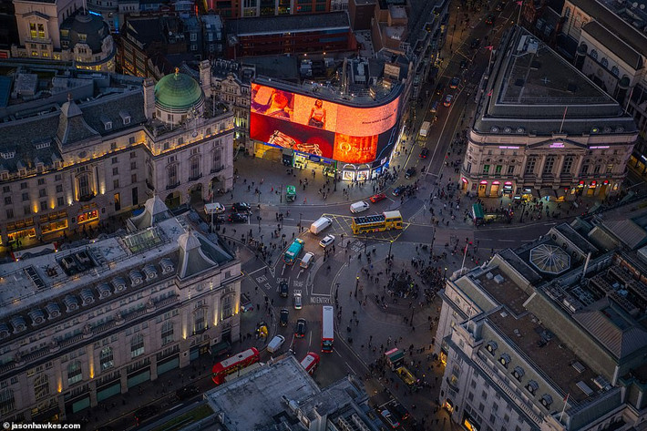 Daily Mail mới đây đăng tải loạt ảnh thủ đô London nhìn từ trên cao do nhiếp ảnh gia Jason Hawkes ghi lại. Ảnh chụp giao lộ nổi tiếng Piccadilly Circus khi màn đêm dần buông xuống. (Nguồn ảnh: Daily Mail)