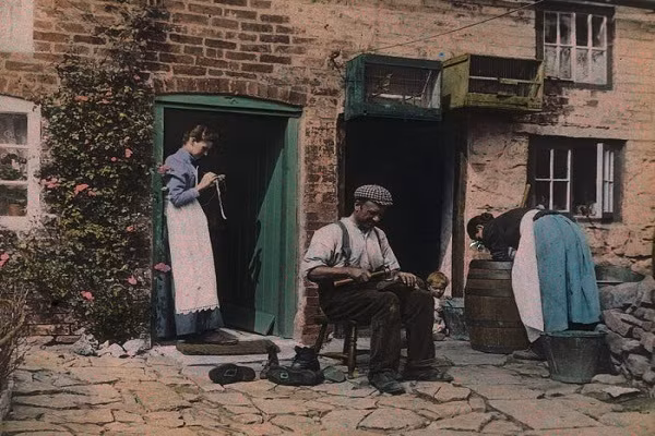 Arthur E. Morton, thư ký của Hiệp hội nhiếp ảnh gia màu, chụp ảnh một người thợ sửa giày trong khi cô gái đứng phía sau đang may vá năm 1912.