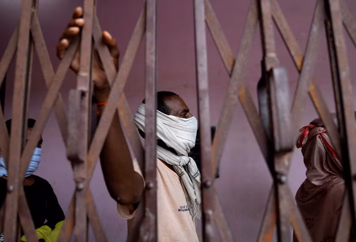 Người đàn ông đứng chờ đến lượt tiêm vắc xin.