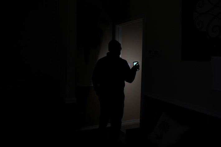 Chuck Pryor, giám đốc nhà tang lễ Pryority Funeral Experience, soi điện thoại đi kiểm tra ở Houston, Texas, ngày 16/2.