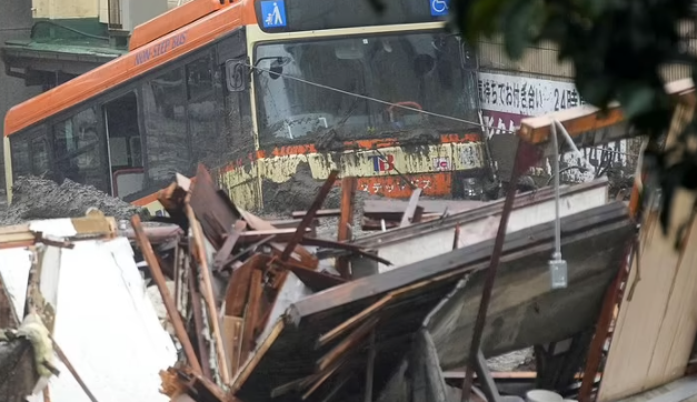 Một chiếc xe buýt bị hư hại nằm giữa đống đổ nát ở Atami sau khi "lũ bùn" quét qua.