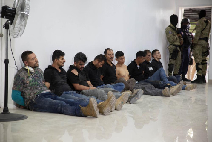 "Chúng tôi sẽ đưa chúng ra trước công lý", cảnh sát trưởng Leon Charles nói trong cuộc họp báo tối 8/7 trong khi 17 nghi phạm bị còng tay.