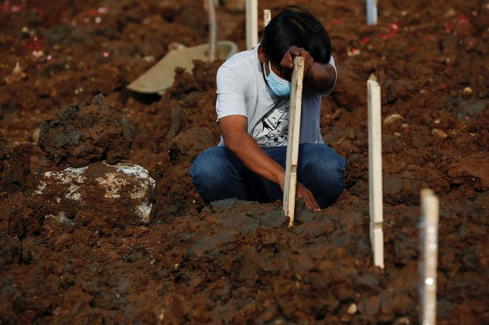 Abdul Rahman ngồi trước mộ của anh trai, Helmi - người đã tử vong vì COVID-19, ngày 24/6.