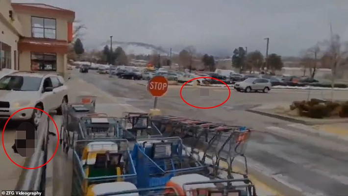 Một đoạn video về vụ xả súng kinh hoàng được đăng tải trên mạng cho thấy 2 nạn nhân (khoanh đỏ) nằm trên mặt đất tại bãi đỗ xe của siêu thị.