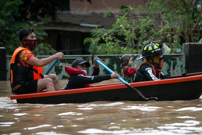 Lực lượng cứu hộ hỗ trợ sơ tán người dân khỏi một ngôi làng bị ngập do bão Vamco ở Marikina. 