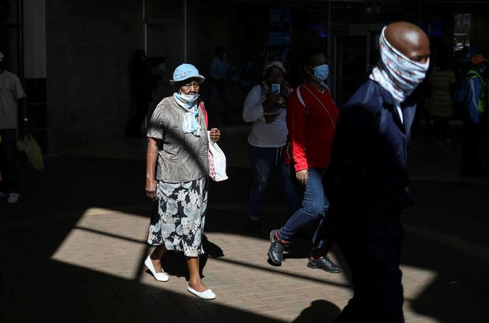 Người dân địa phương đi bộ tại một trung tâm thương mại ở Soweto hôm 4/5 khi Nam Phi bắt đầu nới lỏng một số biện pháp hạn chế.