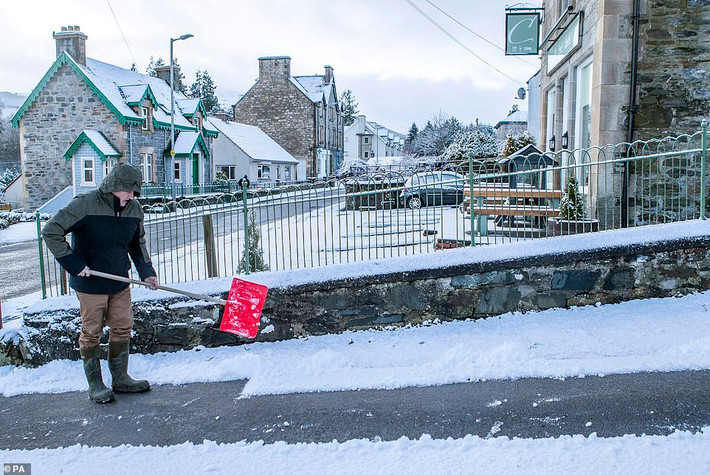 Người đàn ông dọn tuyết trên đường ở Stirlingshire.