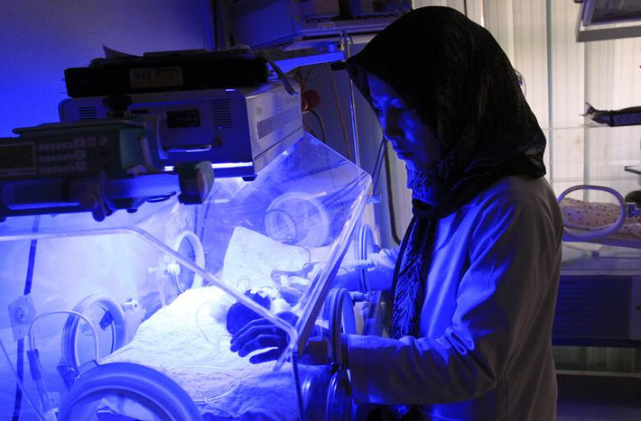Một nữ hộ sinh người Afghanistan chăm sóc những đứa trẻ sơ sinh tại bệnh viện Cure International ở Kabul vào ngày 8/5/2012.