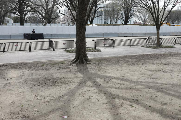 Nhân viên Mật vụ Mỹ đứng gác dọc Đại lộ Pennsylvania vắng tanh phía bên ngoài Nhà Trắng hôm 16/3.