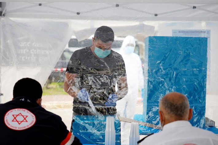 Được biết, Ủy ban Bầu cử Israel đã thiết lập những điểm bỏ phiếu đặc biệt để những người dân Israel đang bị cách ly vì dịch COVID-19 vẫn có thể đi bỏ phiếu. Ảnh: Một cử tri đeo khẩu trang và găng tay đi bỏ phiếu tại Ashkelon ngày 2/3.