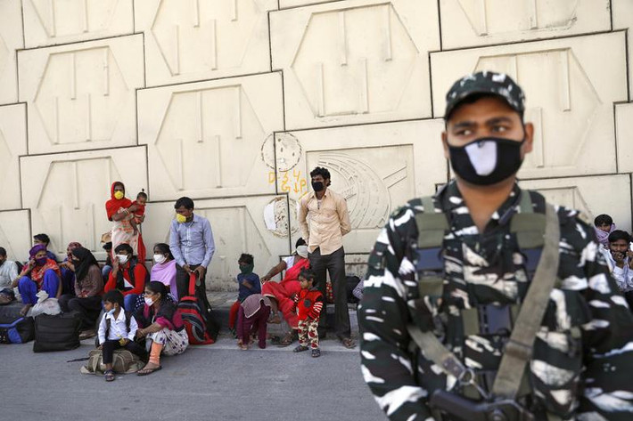 Nhiều lao động cố chờ xe buýt trên đường cao tốc ở ngoại ô thủ đô New Delhi để trở về quê hôm 28/3.