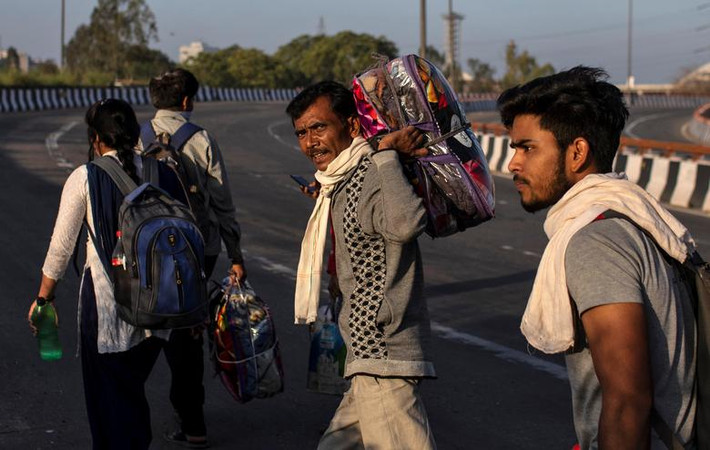 Người đàn ông mang theo đồ đạc đi bộ về làng hôm 30/3.