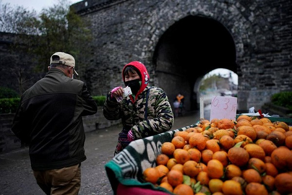 Một người bán hoa quả trên đường phố ở Kinh Châu ngày 27/3.