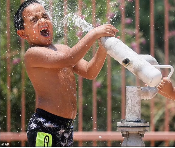 Em nhỏ chơi nghịch nước ở Tucson, bang Arizona. Ảnh: AP.