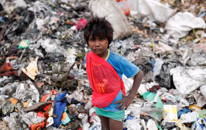Một em nhỏ mưu sinh trên bãi rác ở thủ đô Ấn Độ.