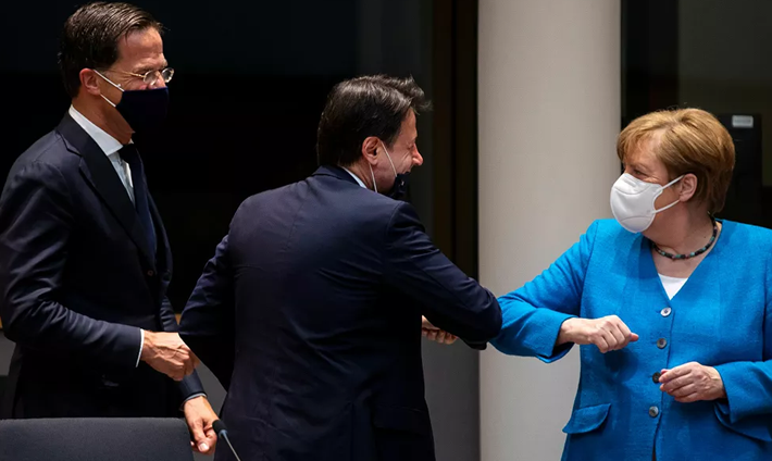Thủ tướng Đức Angela Merkel chào Thủ tướng Italy Giuseppe Conte bằng cách chạm khuỷu tay tại cuộc họp bên lề Thượng đỉnh EU ở Brussels, Bỉ, ngày 18/7. Các nhà lãnh đạo EU đều đeo khẩu trang để phòng ngừa lây nhiễm COVID-19.