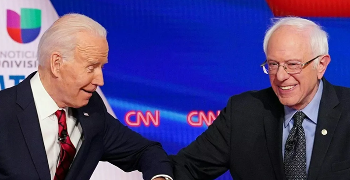 Cựu Phó Tổng thống Mỹ Joe Biden (trái) và Thượng nghị sĩ Bernie Sanders chào nhau thời dịch COVID bằng cách chạm cùi chỏ trước khi bắt đầu cuộc tranh luận ở thủ đô Washington ngày 15/3/2020.