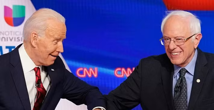 Cựu Phó Tổng thống Mỹ Joe Biden (trái) và Thượng nghị sĩ Bernie Sanders chào nhau thời dịch COVID bằng cách chạm cùi chỏ trước khi bắt đầu cuộc tranh luận ở thủ đô Washington ngày 15/3/2020.