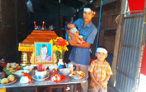 Chồng và 2 con nhỏ dại bên cạnh quan tài chị Mỹ.