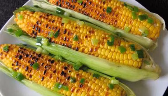 Bắp nướng mỡ hành: Từng trái bắp vàng mọng trở qua trở lại trên bếp than hồng tuy có lâu chín thật, nhưng thật đáng để bạn "bõ công" chờ đợi. Ảnh: Foody.