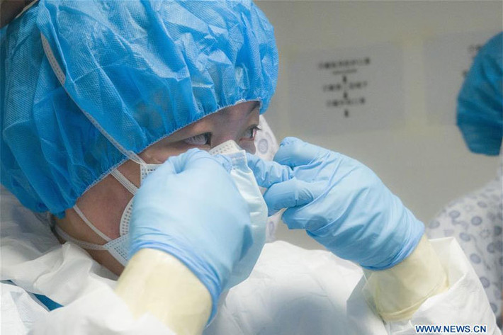 Một nhân viên y tế tự kiểm tra khẩu trang ở khu vực Guanggu thuộc bệnh viện Tongji ở Vũ Hán.