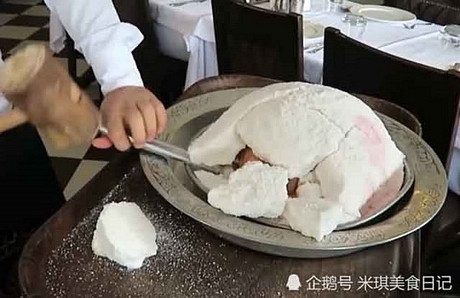 Ban đầu, người đầu bếp châm lửa đốt lên một tảng đá trắng đến mức cháy xém, rồi sau đó dùng búa đập vỡ, từng mảnh vụn rơi ra, dày như miếng gạch để lộ ra bên trong là một con gà được tẩm ướp đầy đủ gia vị và rau thơm.