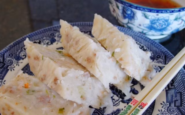 Người làm bánh bào củ cải thành sợi, vắt nước, xào sơ rồi trộn với bột, tùy theo khẩu vị có thể thêm tôm khô, nấm đông cô, ngũ vị hương, lạp xưởng rồi đem hấp chín. Bánh đạt chuẩn có mặt bóng, bột mịn, mềm và thơm, ăn lạ miệng hơn khi chiên. Ảnh: IT.