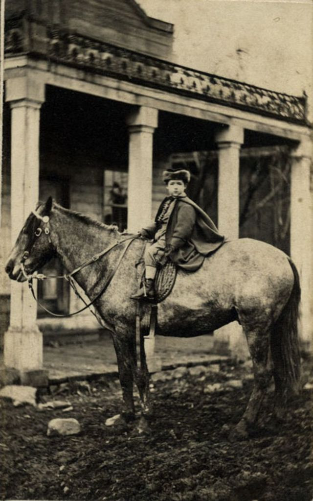 Em bé tạo dáng chụp ảnh khi ngồi trên lưng ngựa. Ảnh chụp ở Latrobe, Pennsylvania những năm 1800.