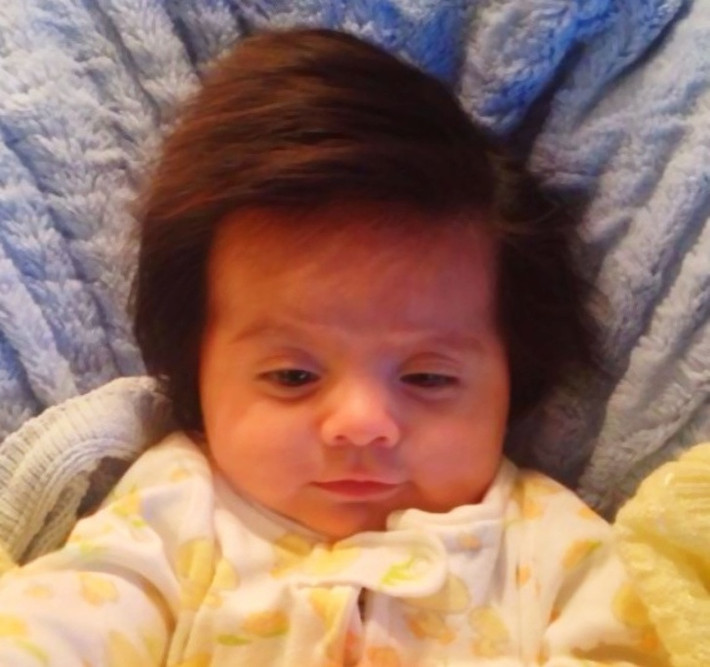 Em bé 2 tháng tuổi có mái tóc đẹp tự nhiên.