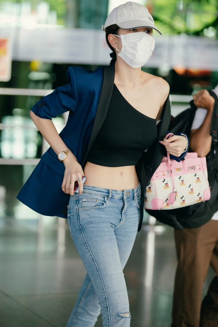 Với áo lệch vai, quần jeans ôm cơ thể, người đẹp khoe trọn vòng eo 55 vô cùng mảnh mai và cuốn hút. Đặc biệt, vòng eo sát bụng, không mỡ thừa cùng làn da trắng nõn đã khiến cho Ngọc Trinh nổi bật hơn nhiều.