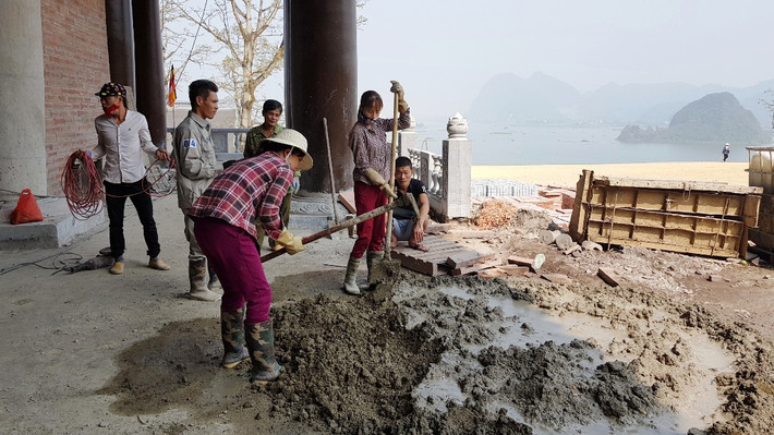 Các công nhân thi công bên ngoài điện Pháp Chủ.