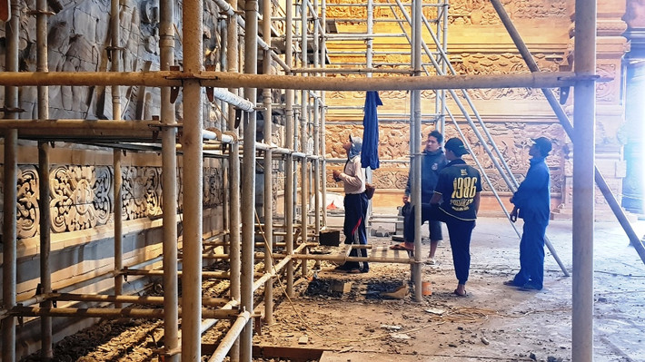 Các nghệ nhân đang hoàn thiện nốt bức tranh bằng đá núi lửa trên tường điện Quan Âm.