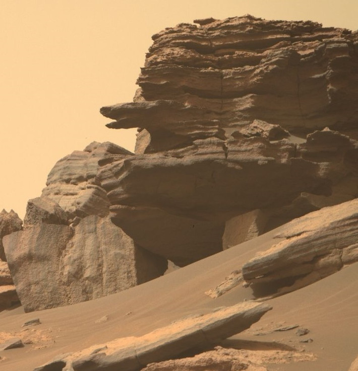 Bức ảnh do NASA công bố gây chú ý với hình dáng một cấu trúc giống "đầu rắn" như đang chui ra từ tảng đá lớn. "Con rắn" này hướng về phía một hình nhân kỳ dị với phần đầu nhỏ trong khi phần thân là tảng đá lớn.