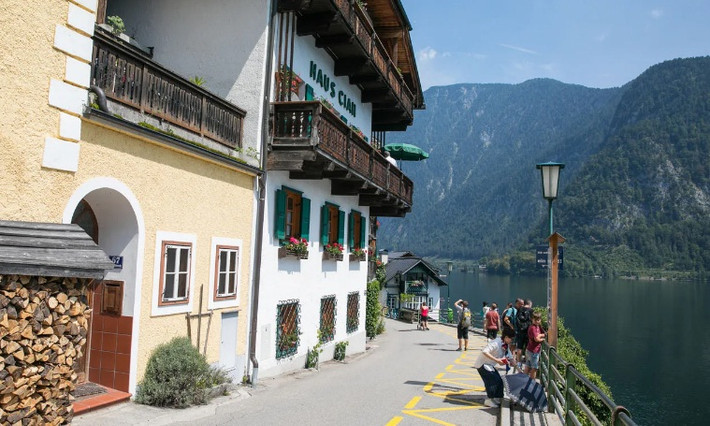 Cụ thể, những ngôi nhà ở Hallstatt nằm dọc triền đồi và nằm chông chênh trên những con dốc hay bên bờ hồ trở nên thơ mộng hơn với những giàn hoa leo rủ xuống từ cửa sổ.
