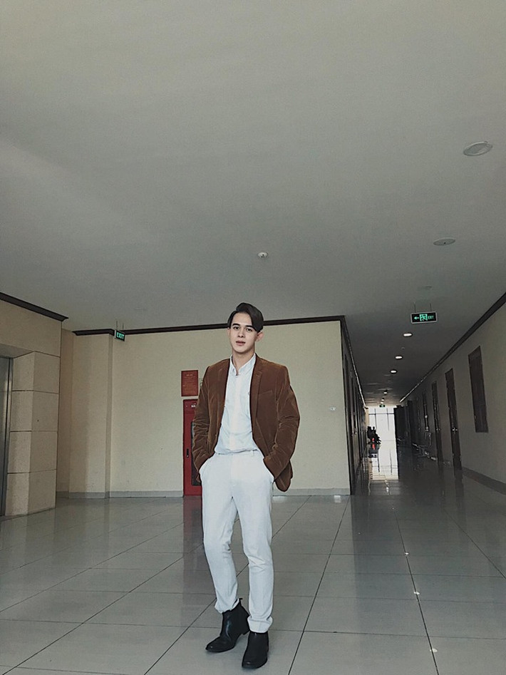 Anh chàng trông càng điển trai hơn khi diện cả cây trắng phối với áo vest nâu.