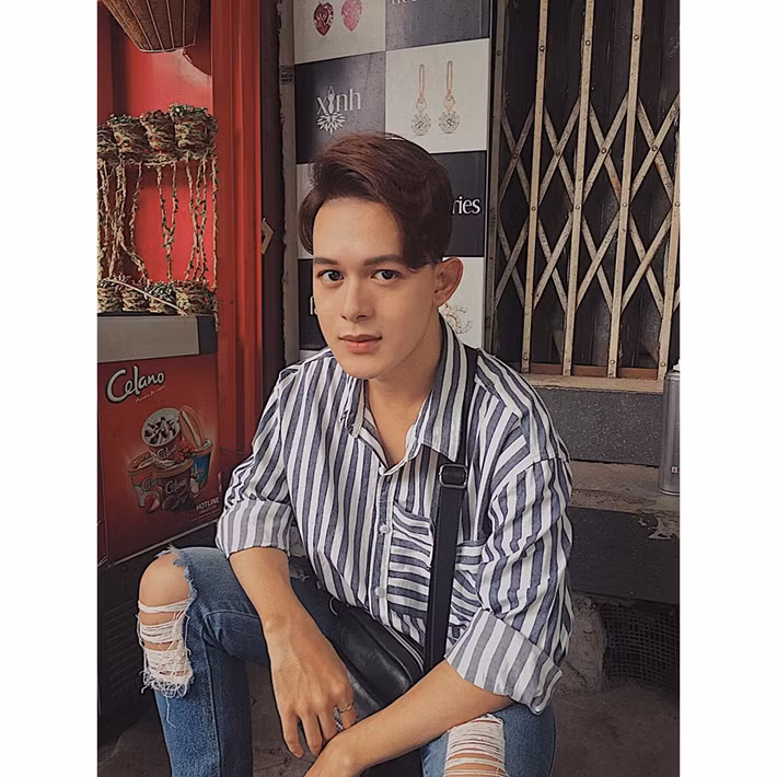 Anh phối áo sơ mi kẻ với quần jean rách cá tính.